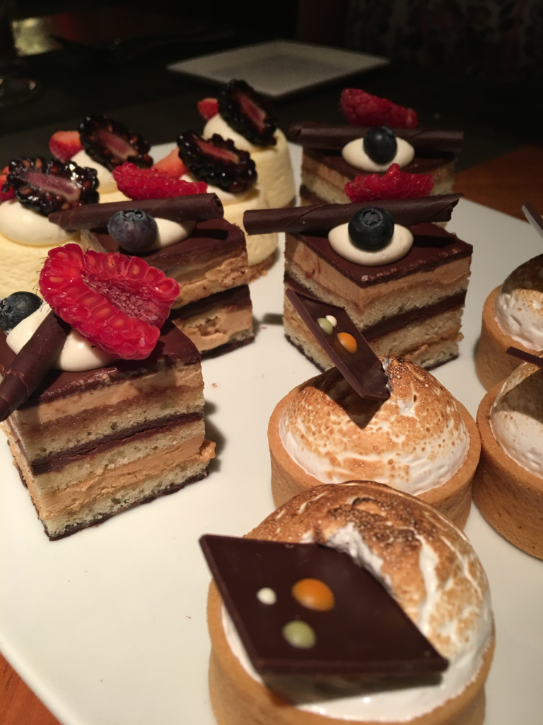 A white plate topped with a variety of desserts