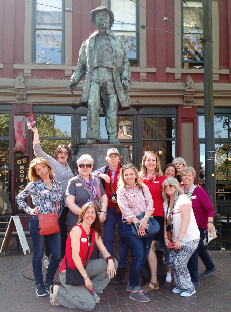 A group of people posing for a picture in front of a statue