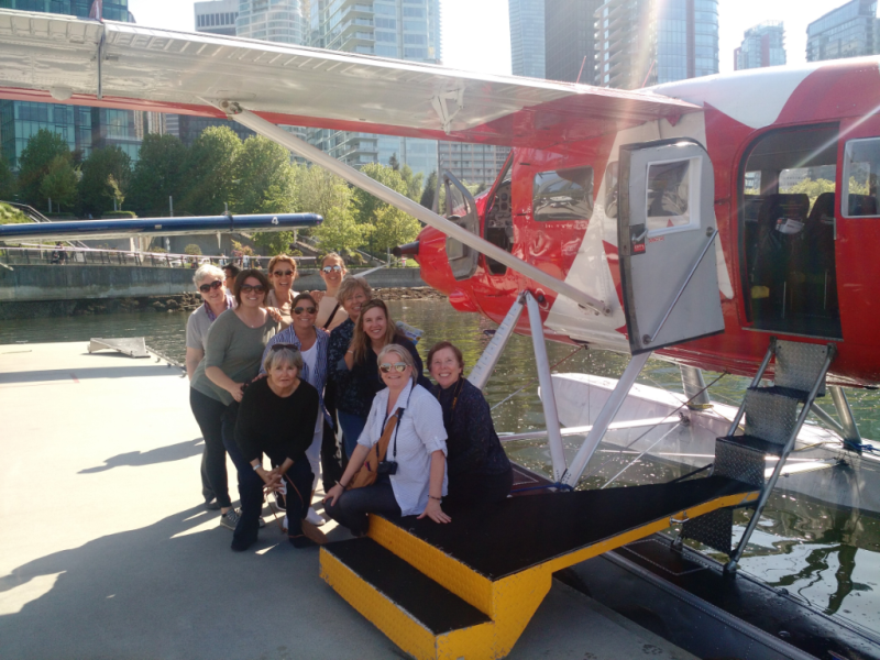 A group of people are posing for a picture in front of a plane
