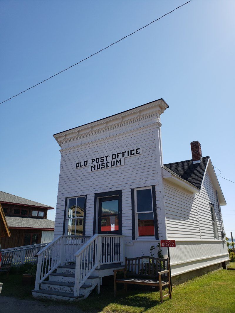 A small white building with the word post office on it