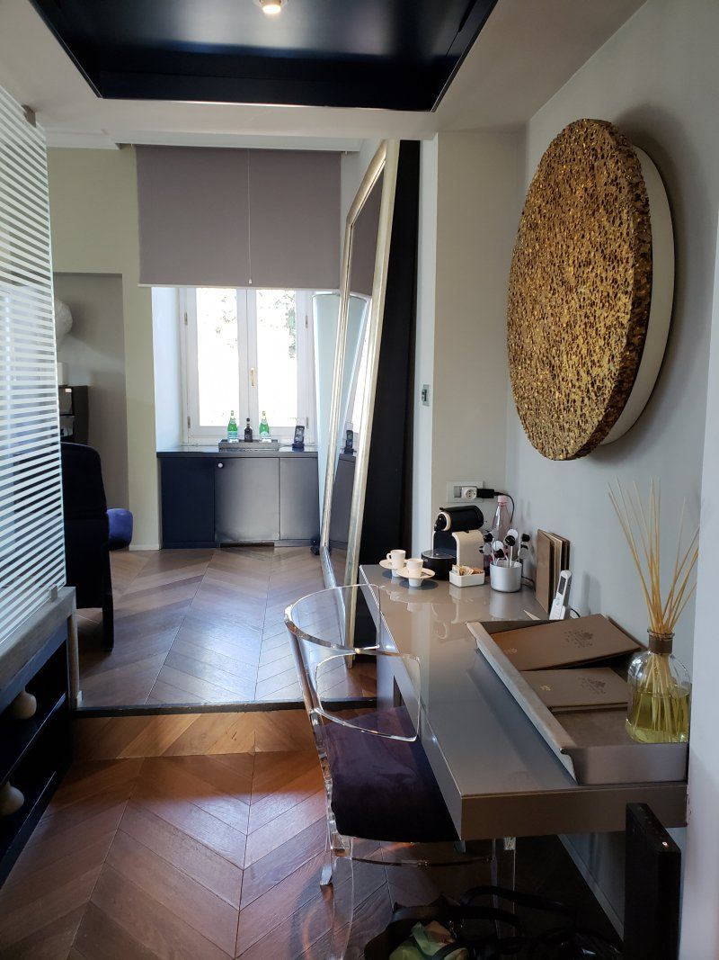 A room with a desk and a large mirror on the wall