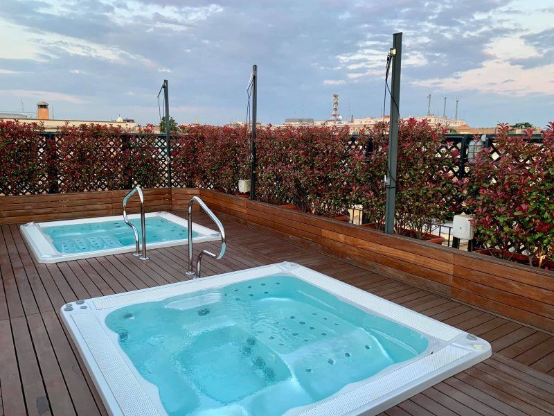 There are two hot tubs on the roof of a building.