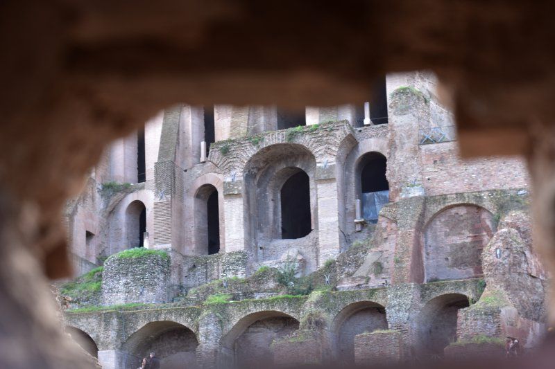 A view of the colosseum through a hole in the wall.