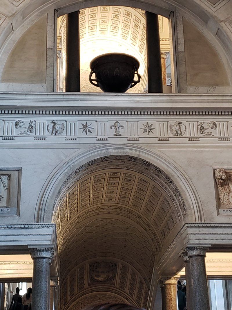 A large urn is hanging from the ceiling of a building.