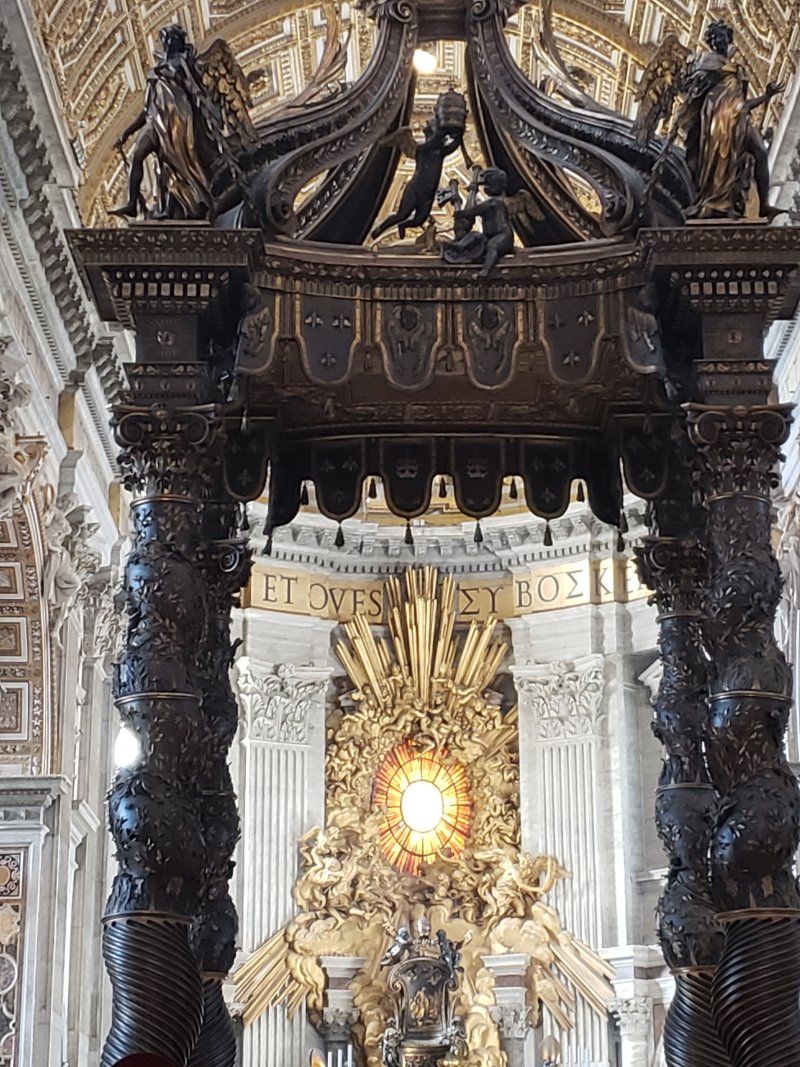 A church with a canopy and a statue of jesus on the altar.