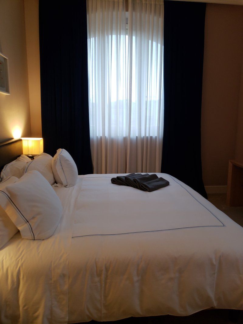 A hotel room with a large bed and a window