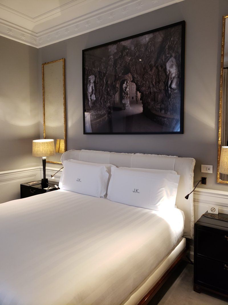 A bedroom with a large bed and a picture on the wall above it.