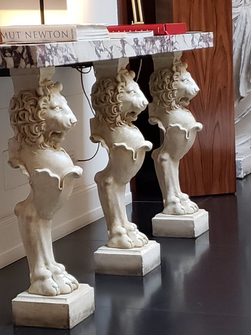 Three statues of lions are sitting next to each other on a table.