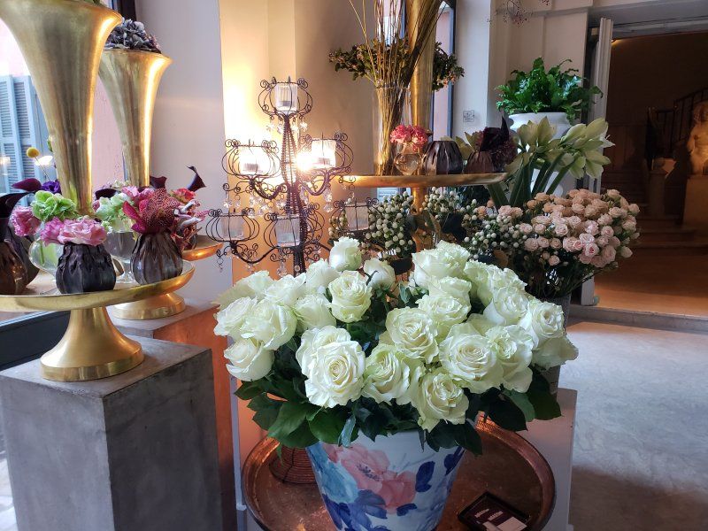 A vase filled with white roses sits on a table