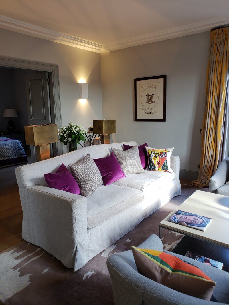 A living room with a white couch and purple pillows