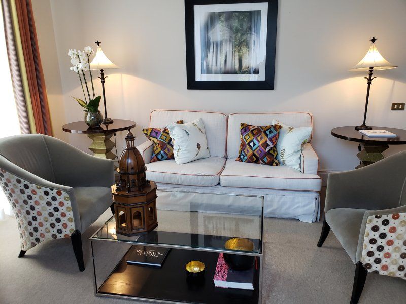 A living room with a couch and two chairs