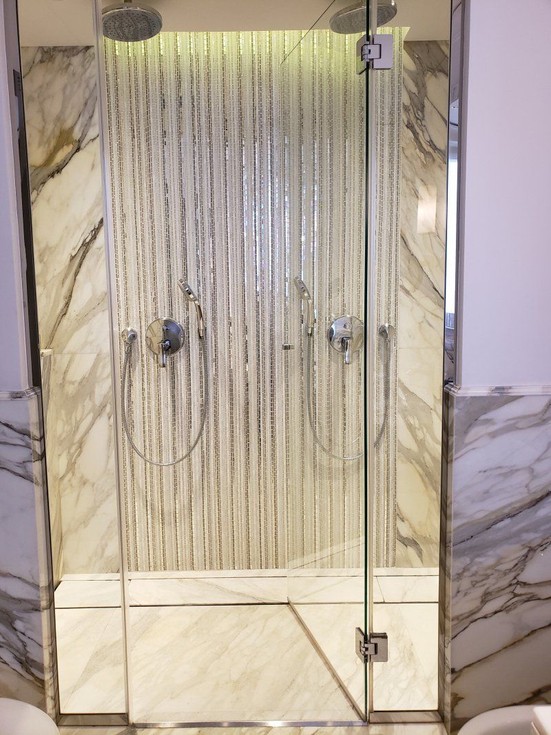 A bathroom with a shower with a glass door