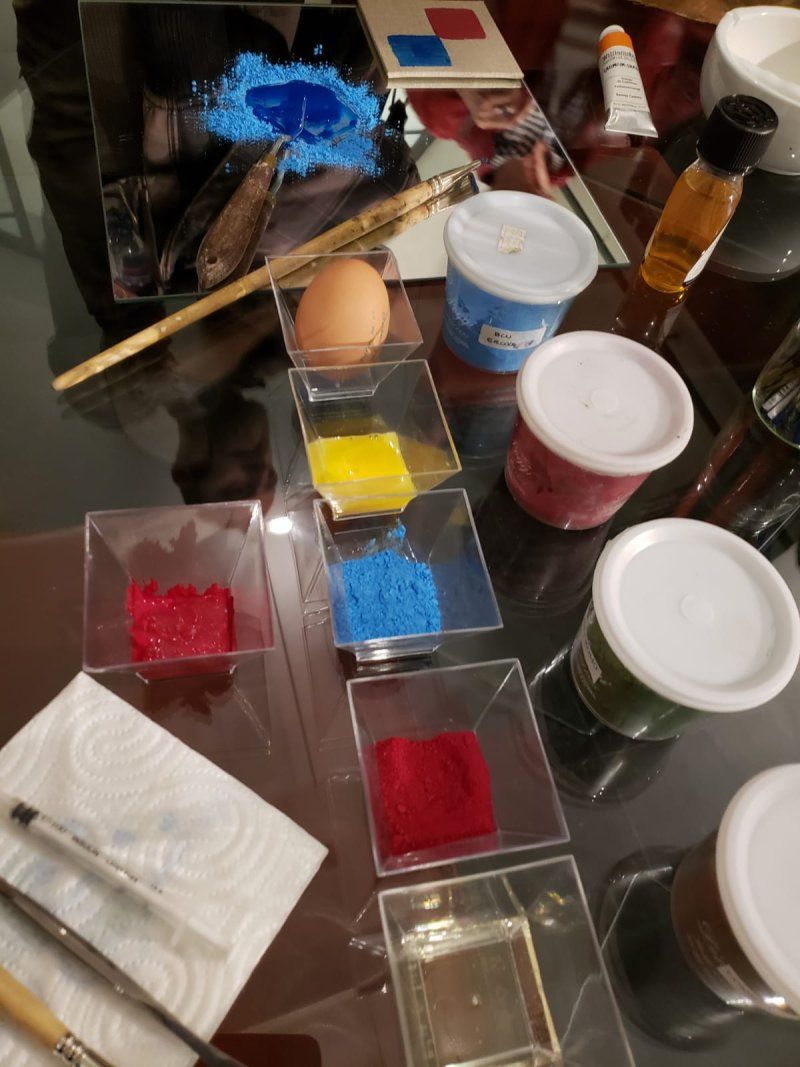 A table topped with containers of paint and brushes