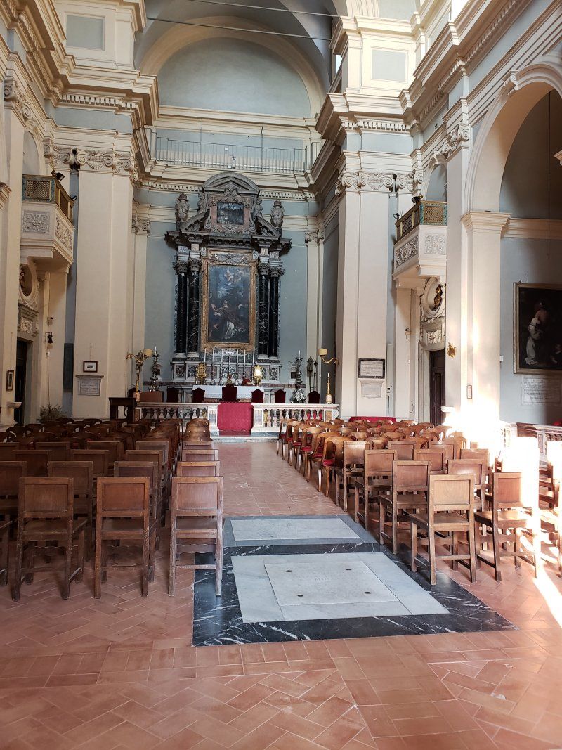 The inside of a church with rows of wooden chairs