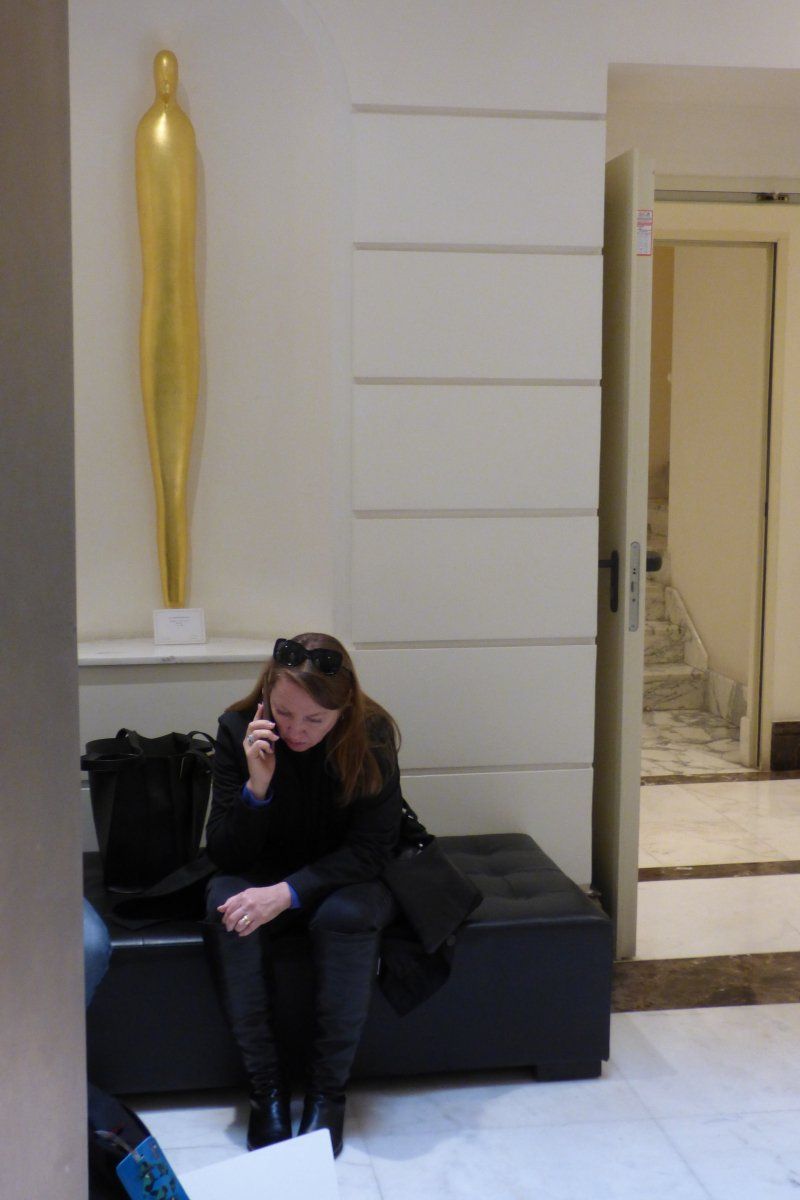 A woman sits on a bench talking on a cell phone