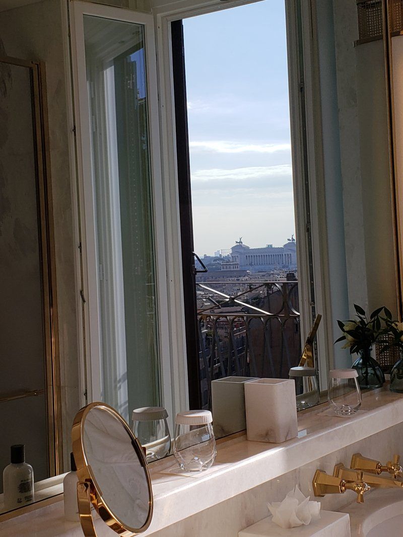 A bathroom with a sink , mirror and window.