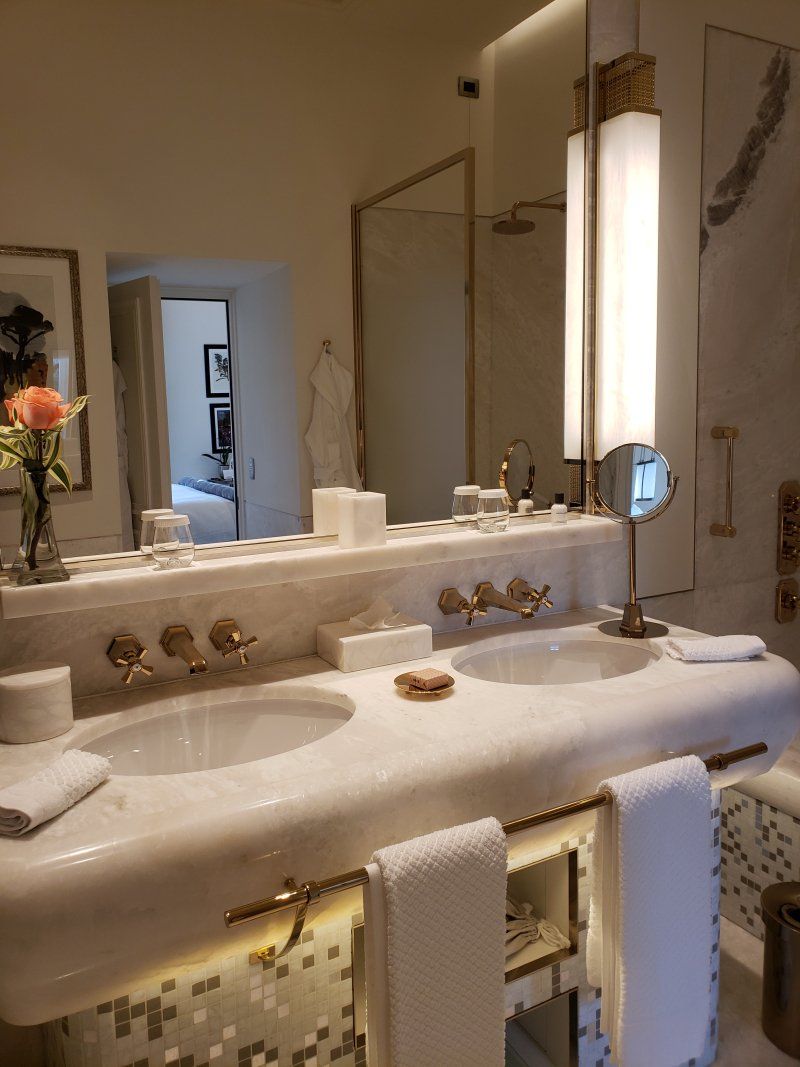 A bathroom with a sink , mirror , and towels.
