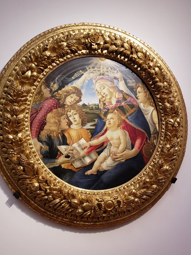 A painting of a woman holding a baby in a gold frame