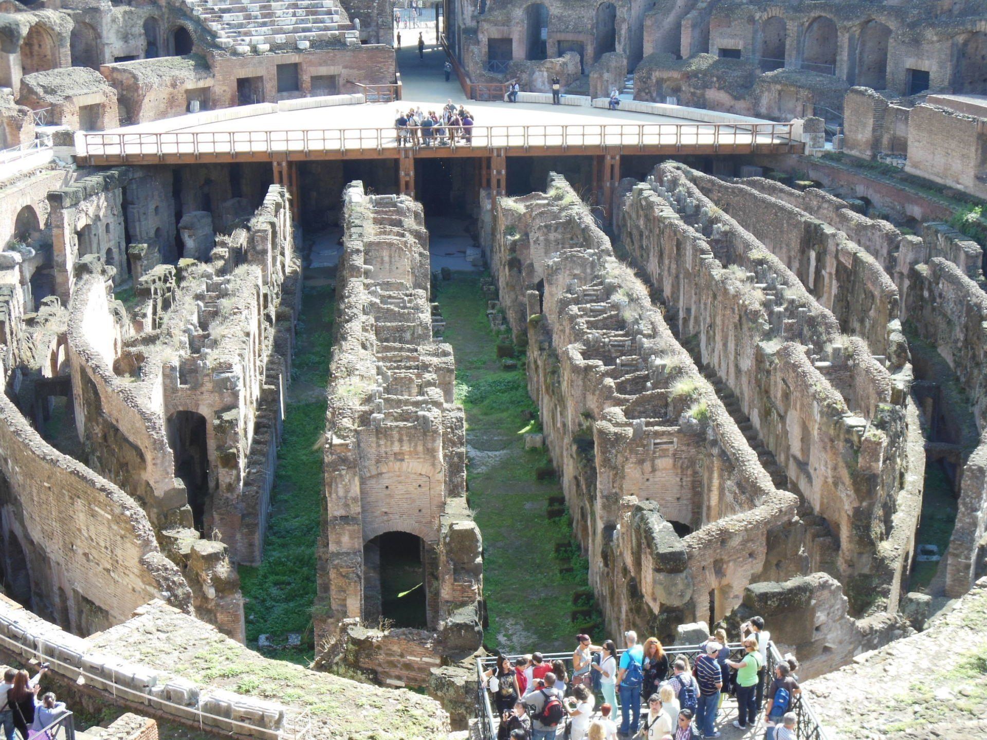 A group of people are standing in the ruins of the colosseum