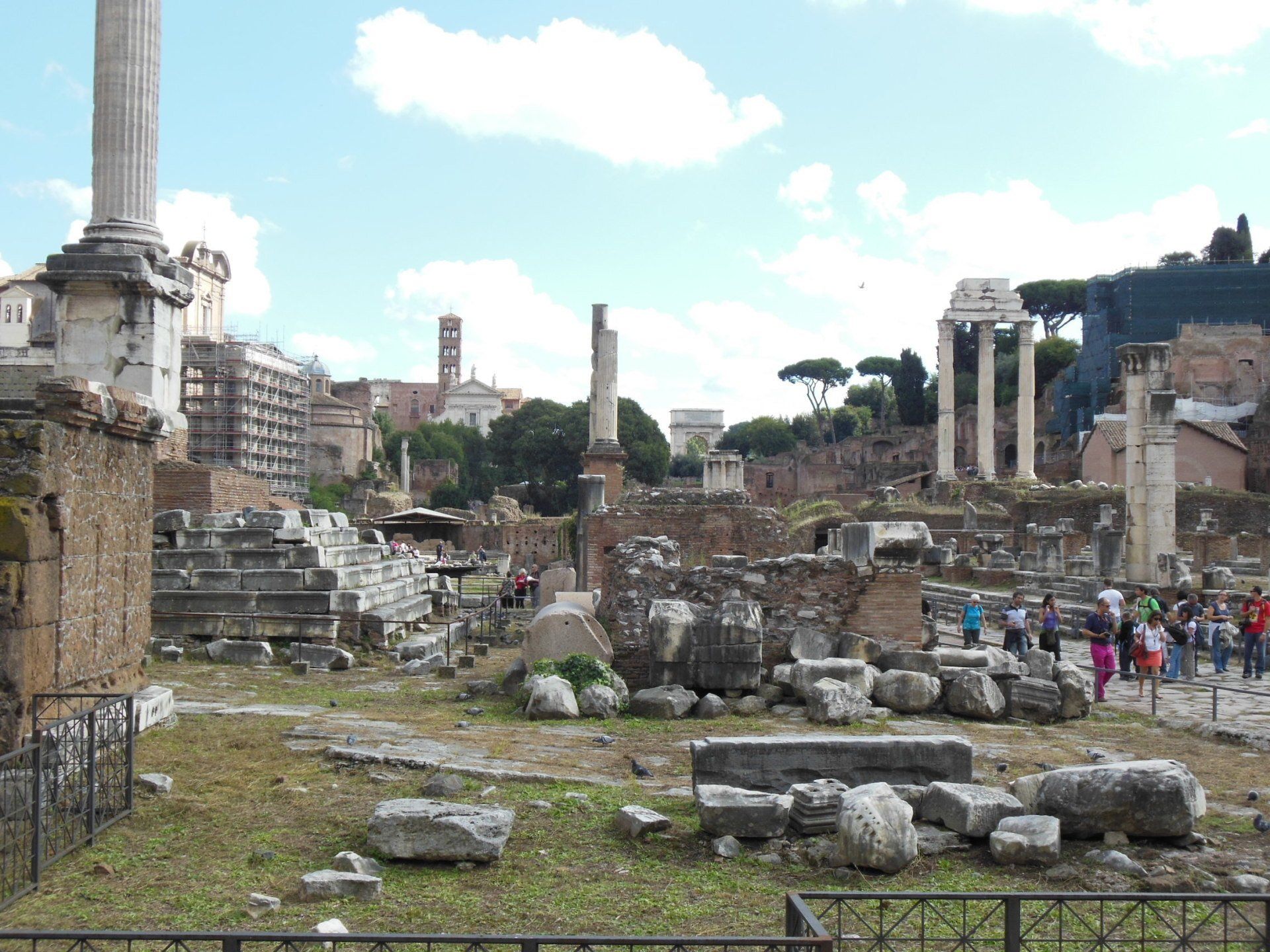 A group of people are walking through a ruined city.