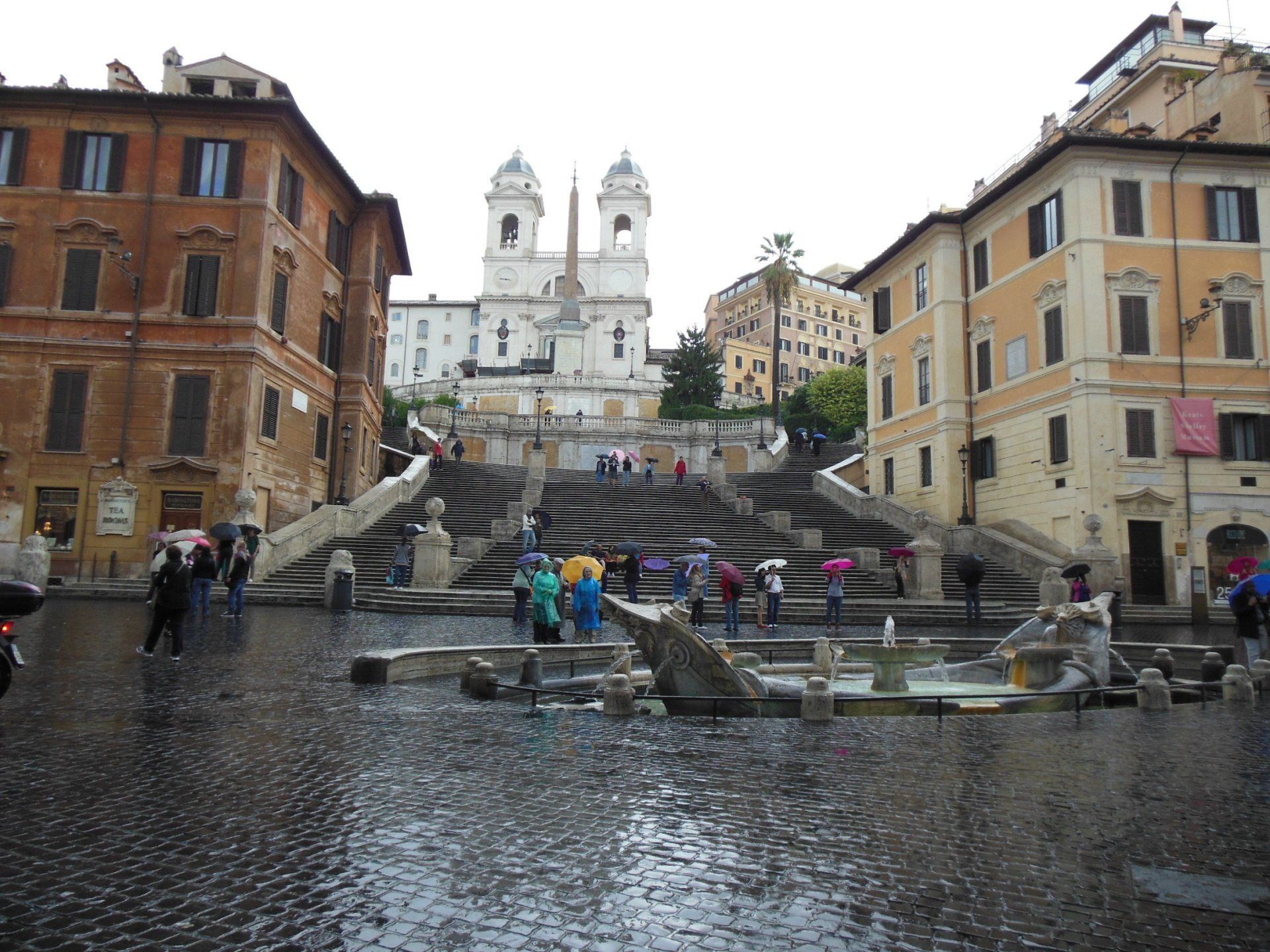A group of people are walking down a set of stairs in the rain