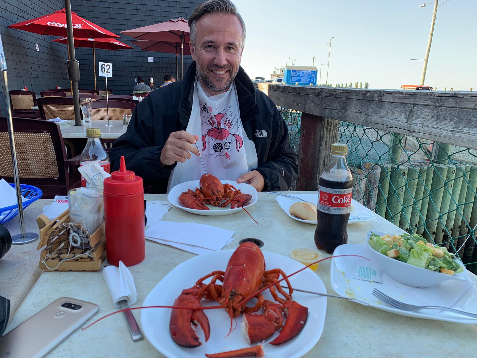 A man is sitting at a table eating lobster.