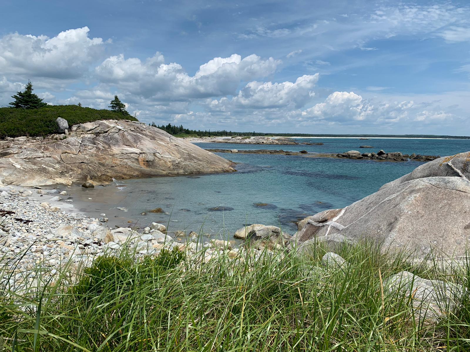 A rocky beach with a large body of water in the background