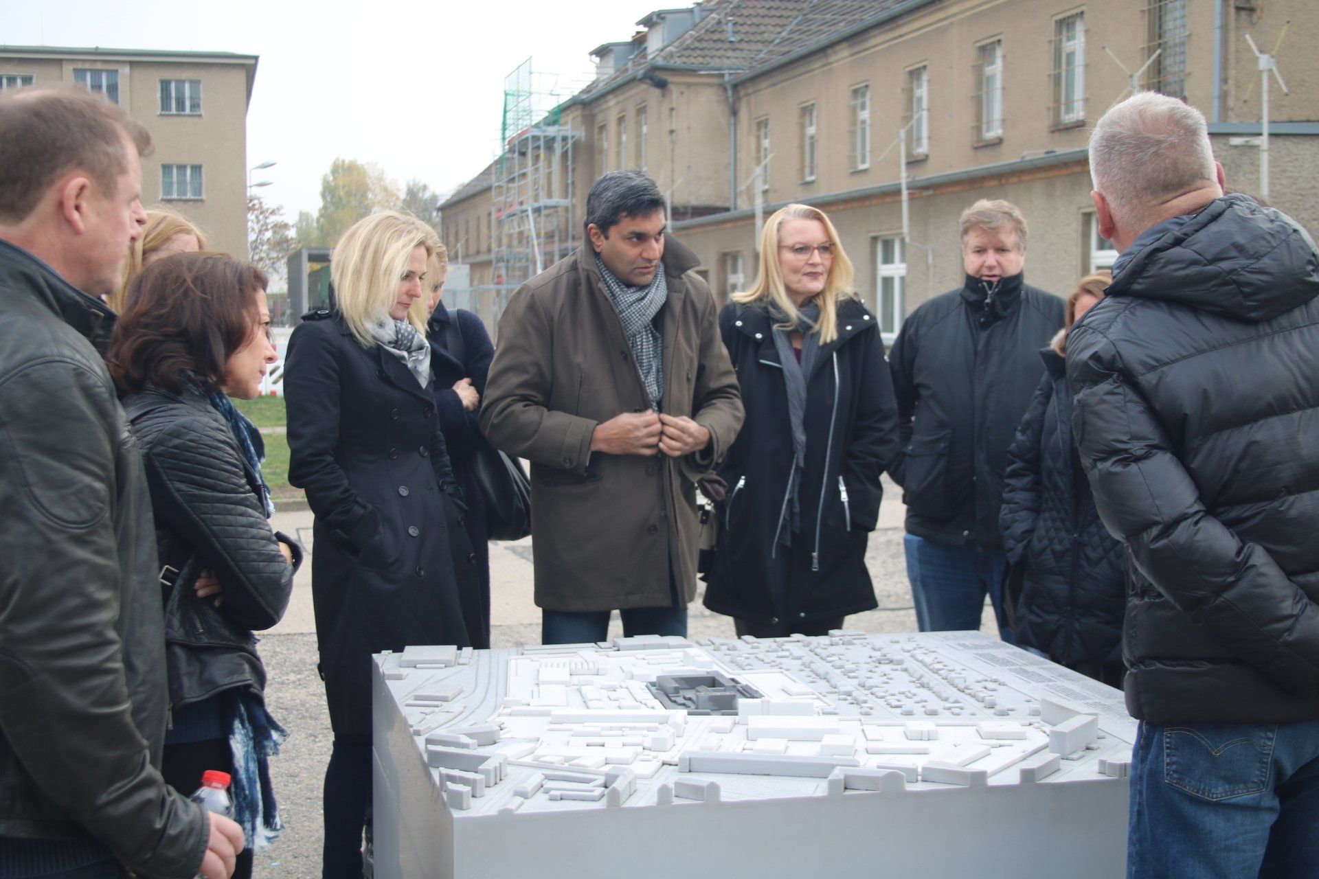 A group of people are standing around a model of a city.
