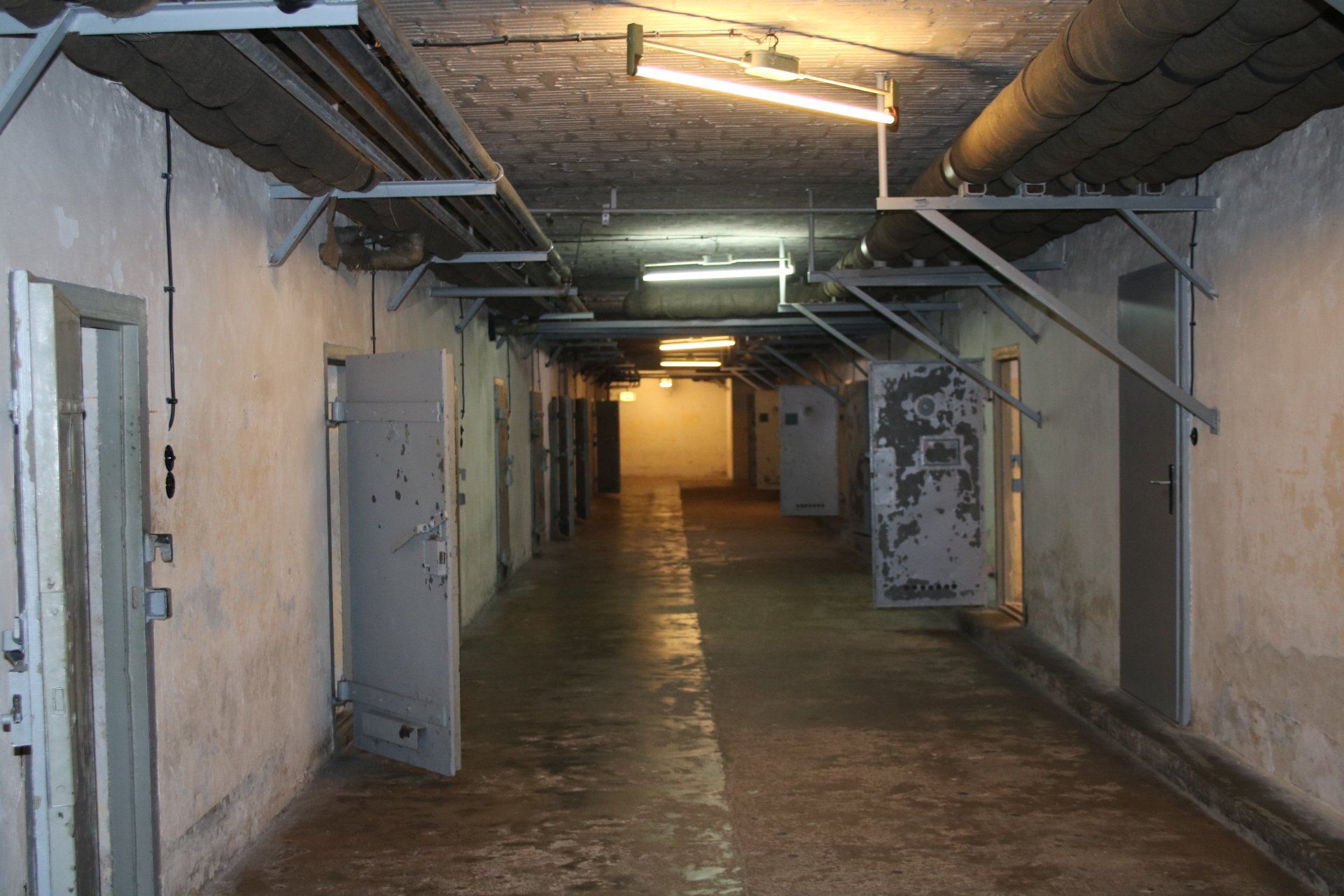 A long hallway in a building with a lot of doors.