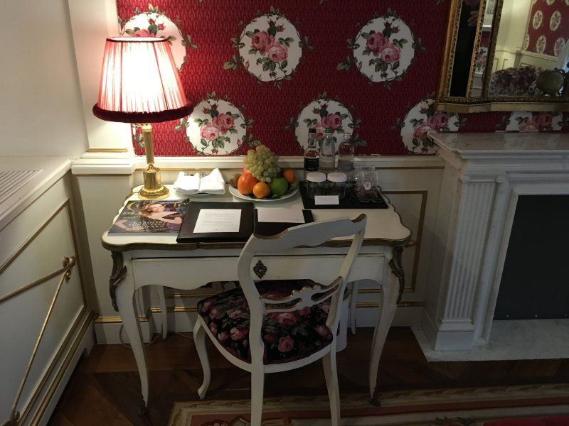 A desk with a lamp and a bowl of fruit on it