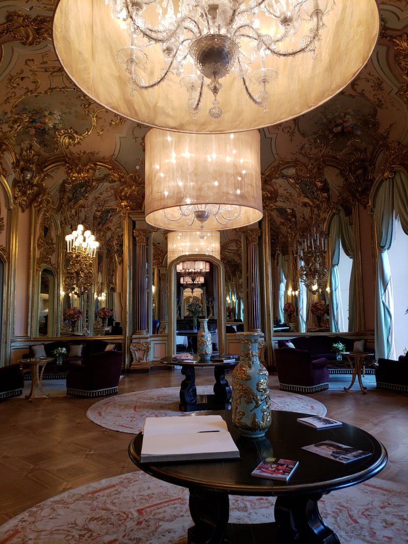 A large room with a table and a chandelier hanging from the ceiling.