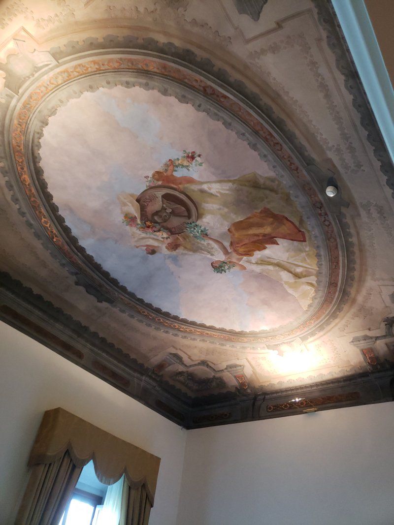 There is a painting on the ceiling of a room.