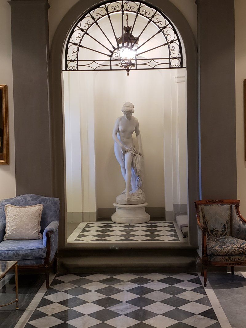 A room with a checkered floor and a statue in the middle
