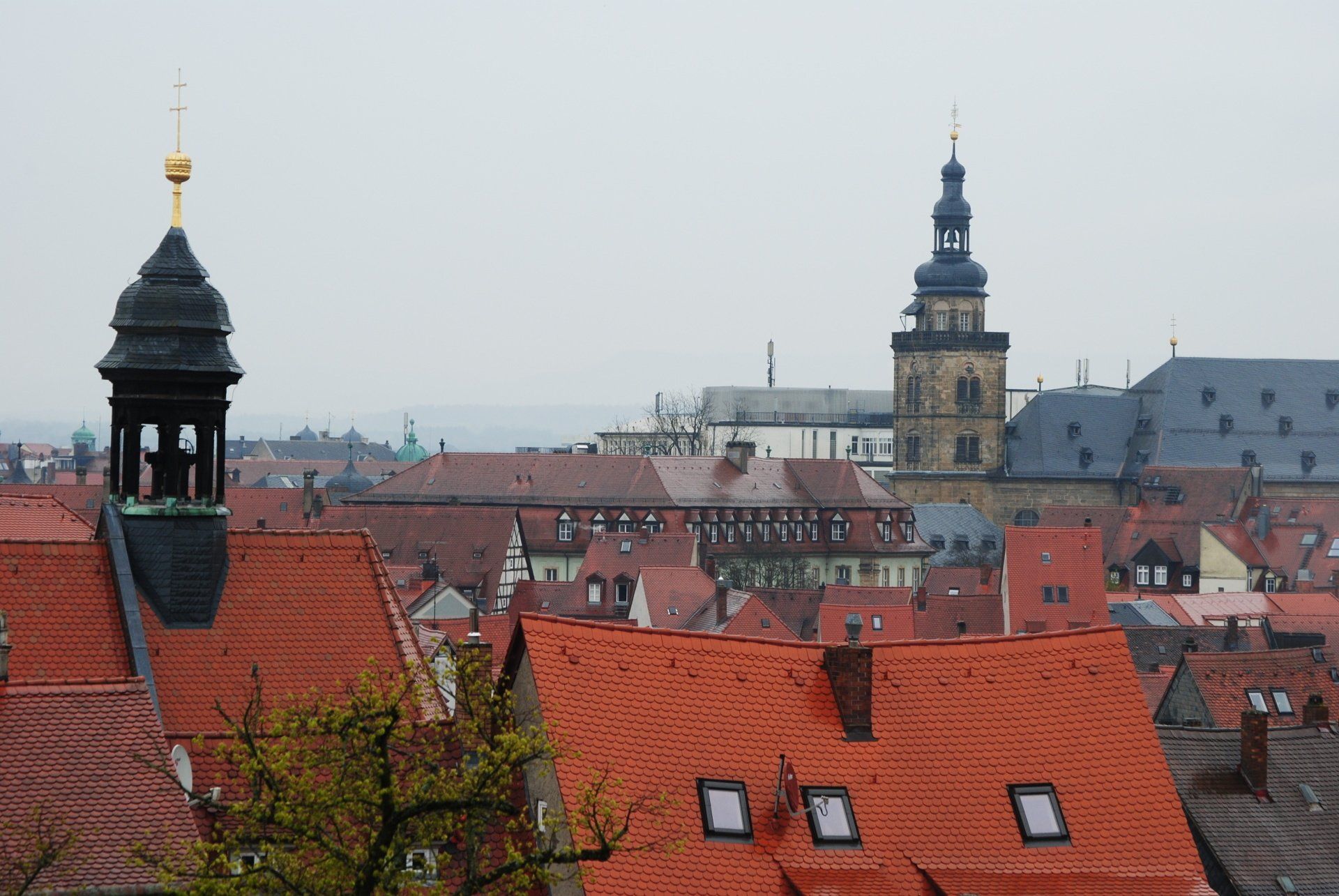 A view of a city with a clock tower in the foreground