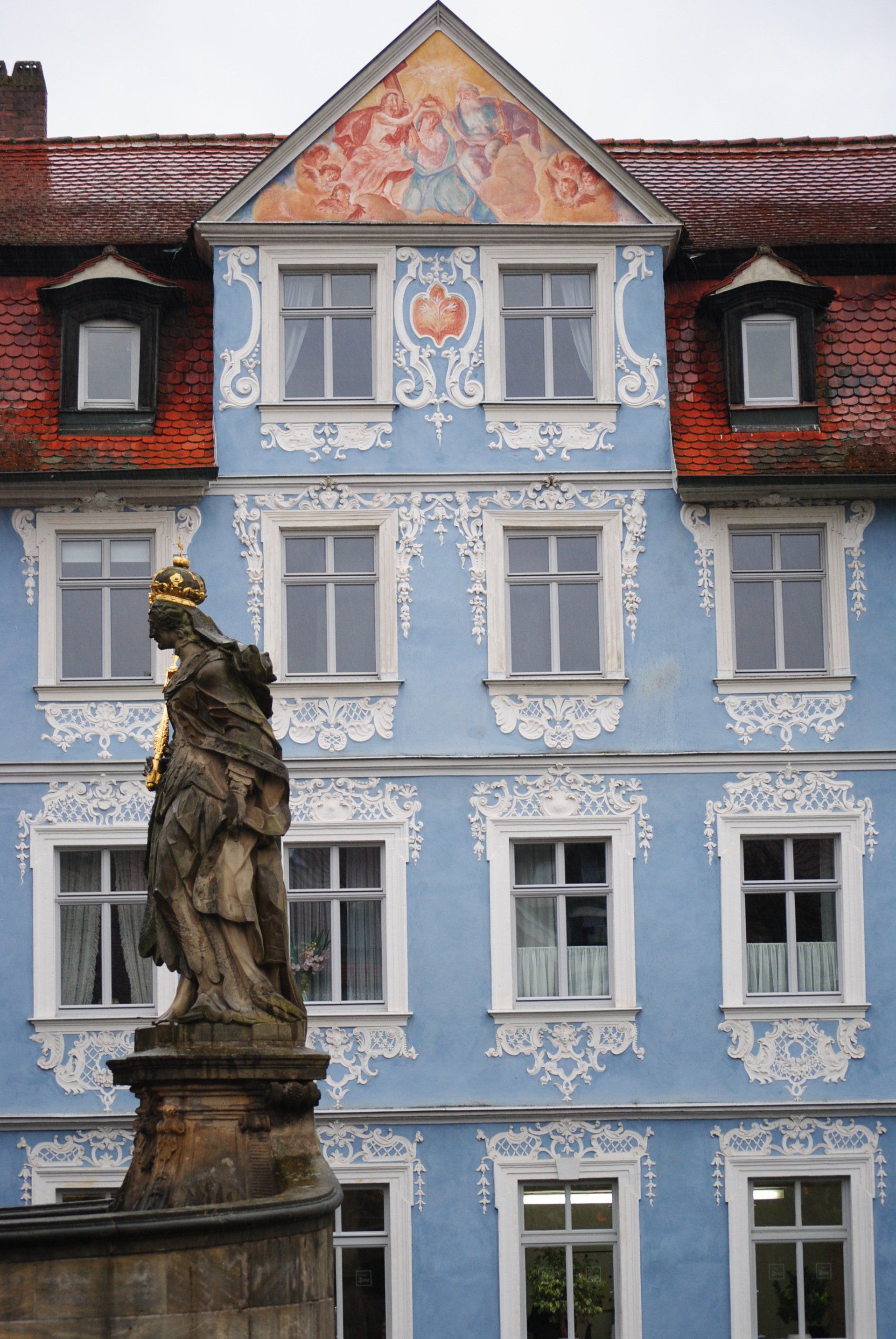 A blue building with a statue in front of it