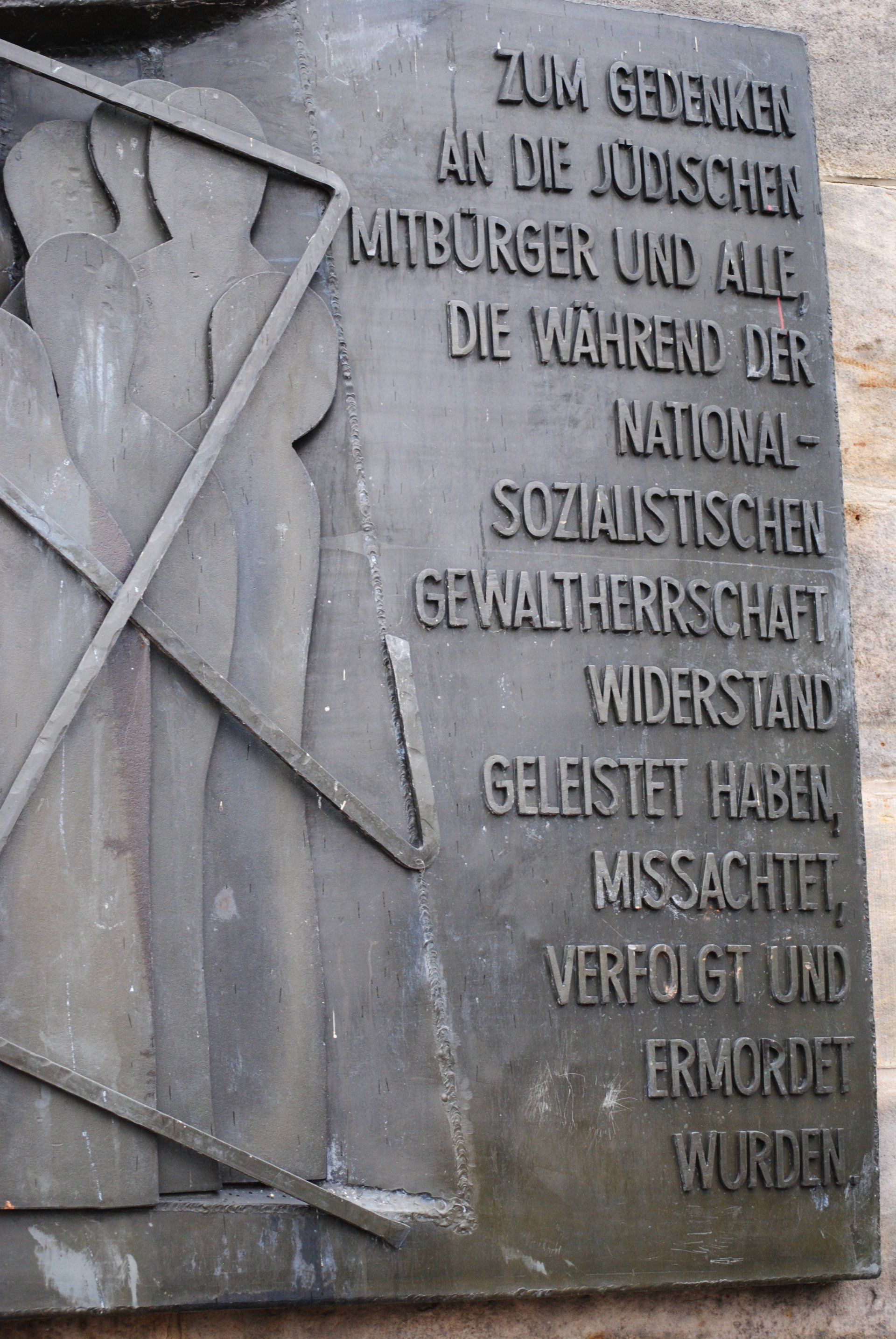 A plaque with a picture of a man holding a stick on it