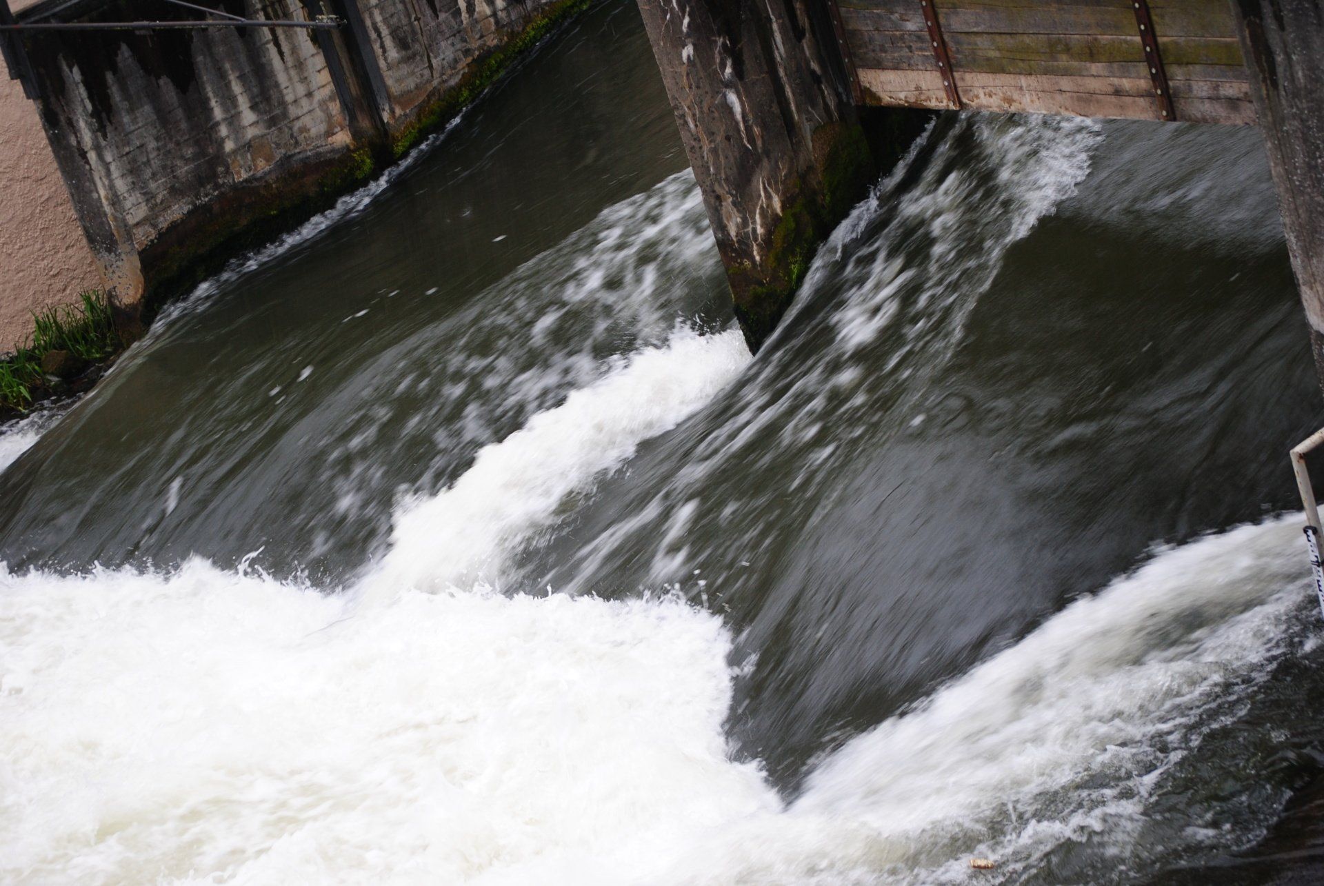 A close up of a waterfall with a building in the background