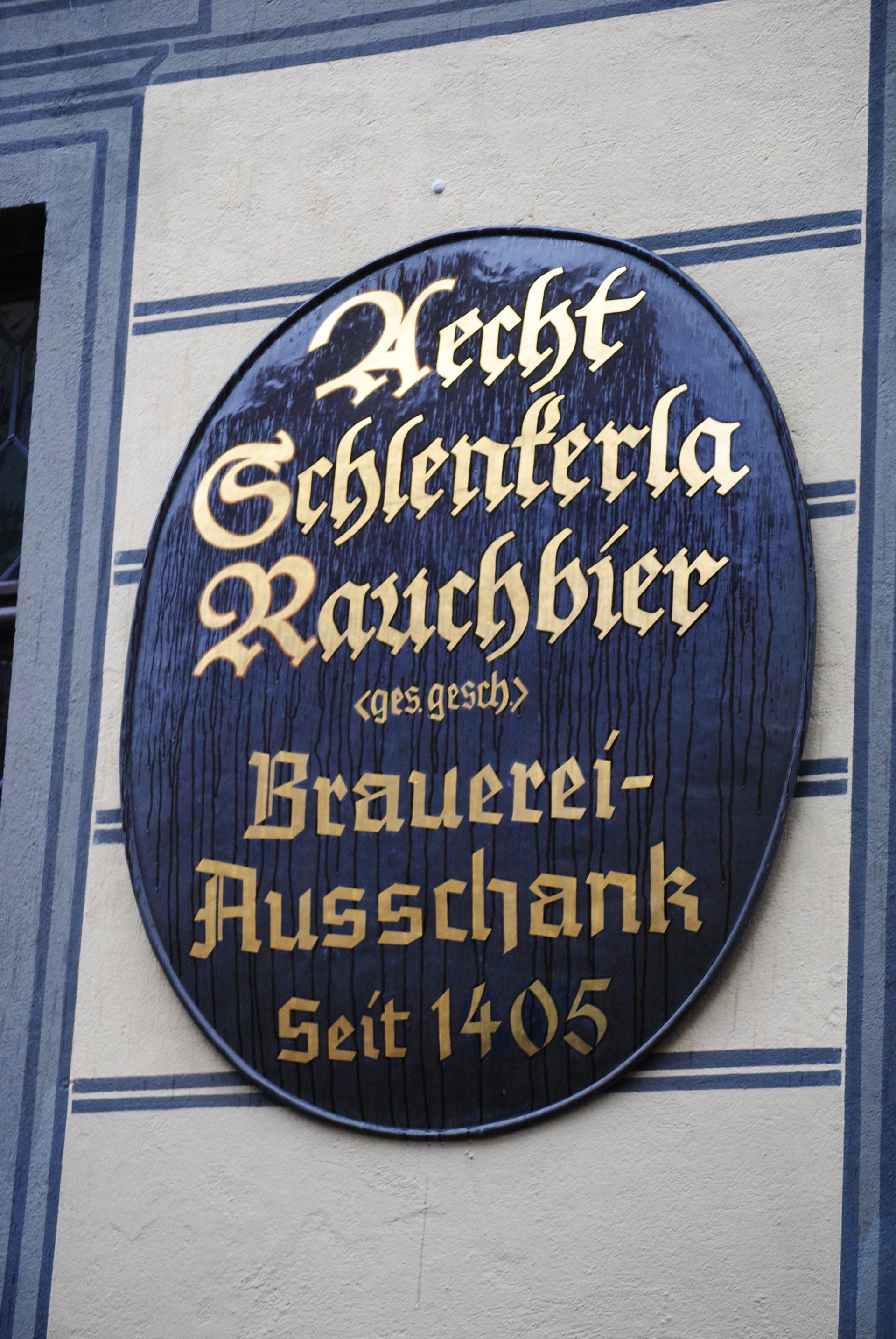 A sign on the side of a building says brecht schlenterla rauchbier brauerei-ausschank seit 1405