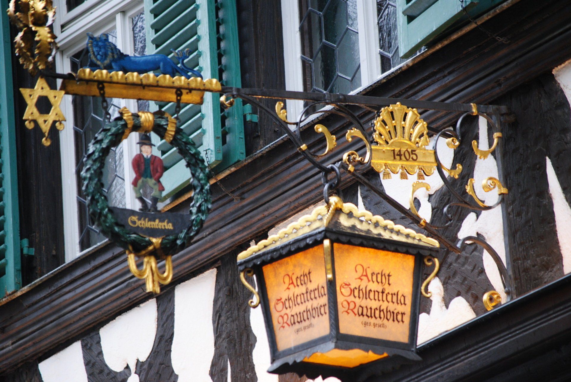 A sign on the side of a building with a lantern hanging from it