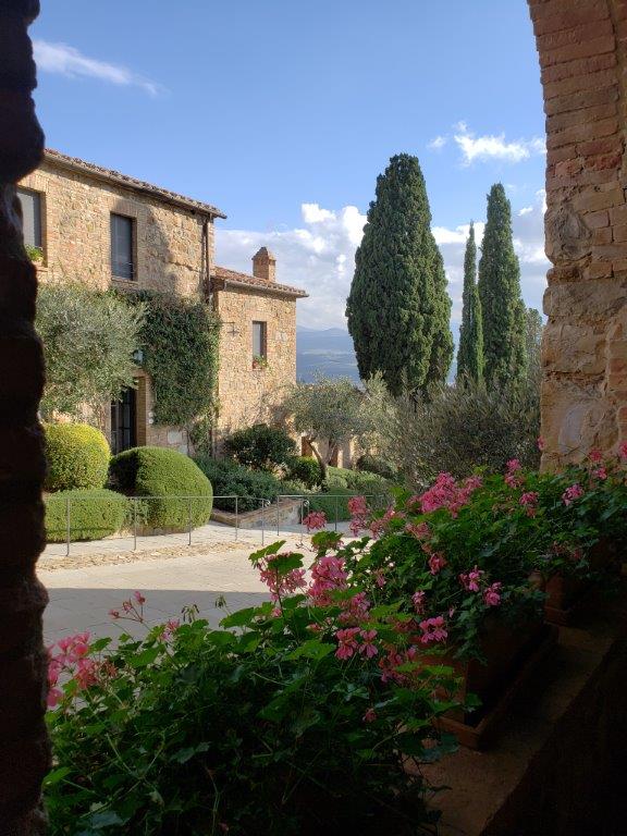 A view of a stone building with flowers in front of it