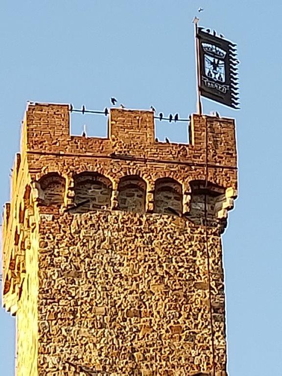 A clock tower with a flag on top of it
