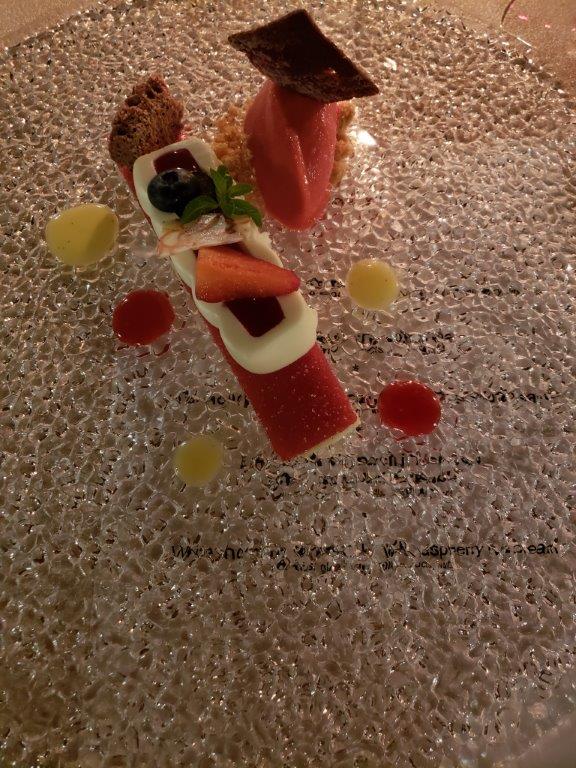 A close up of a dessert with strawberries and chocolate on a plate