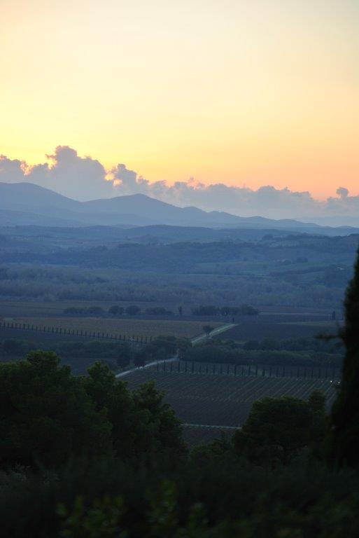 A sunset over a valley with mountains in the background