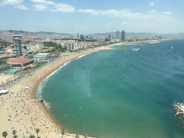 An aerial view of a beach with a city in the background.