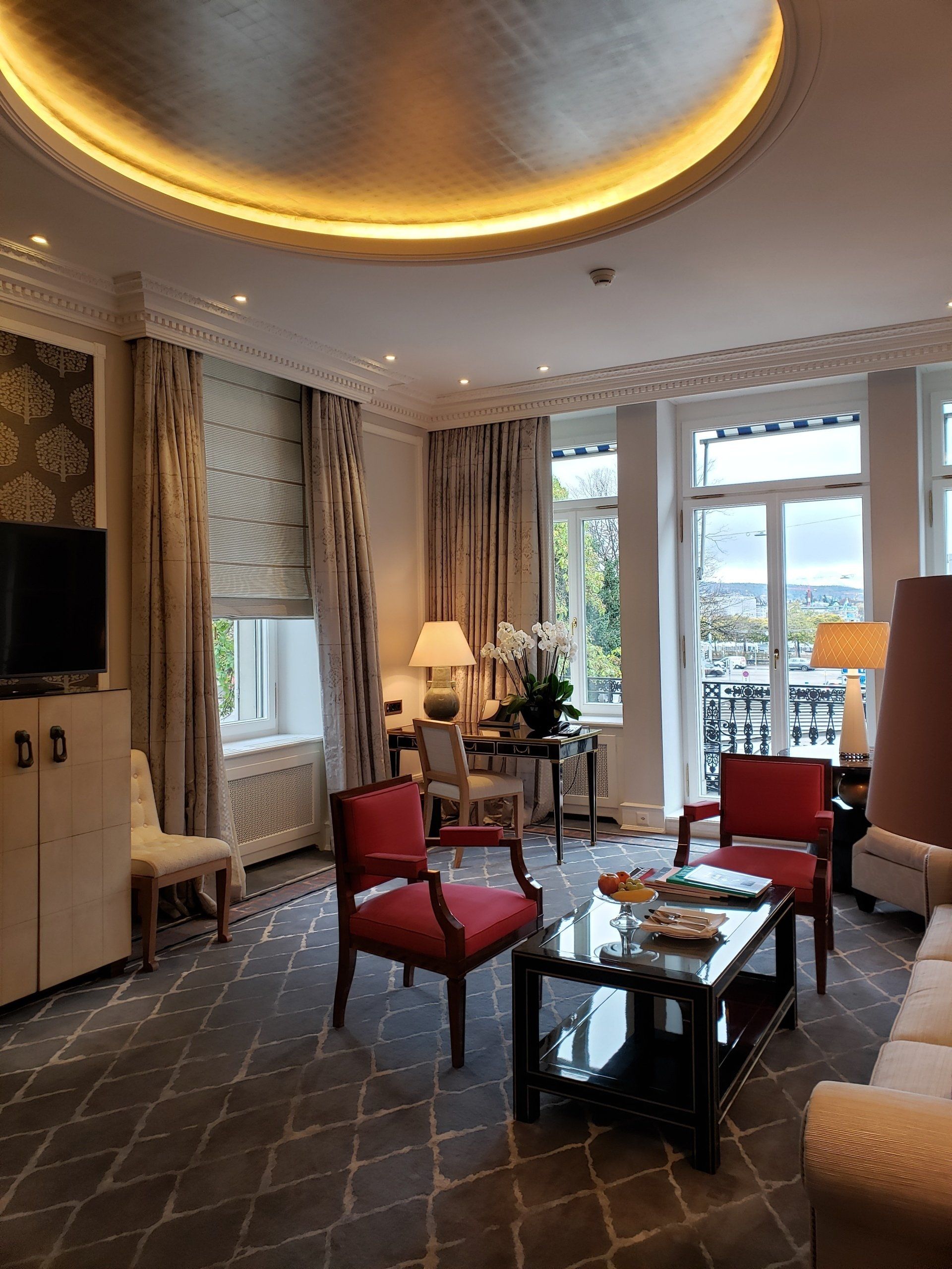 A living room with a couch , chairs , a coffee table and a television.