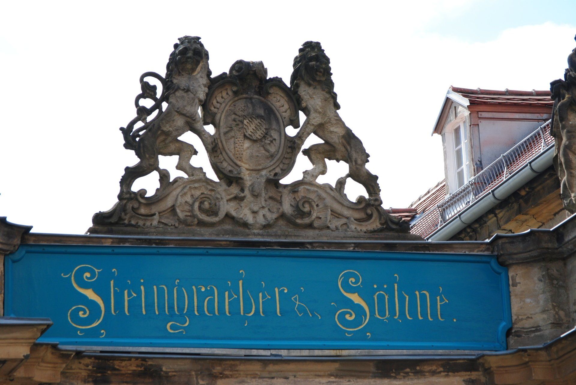 A blue sign on a building that says stringbarbers schnur