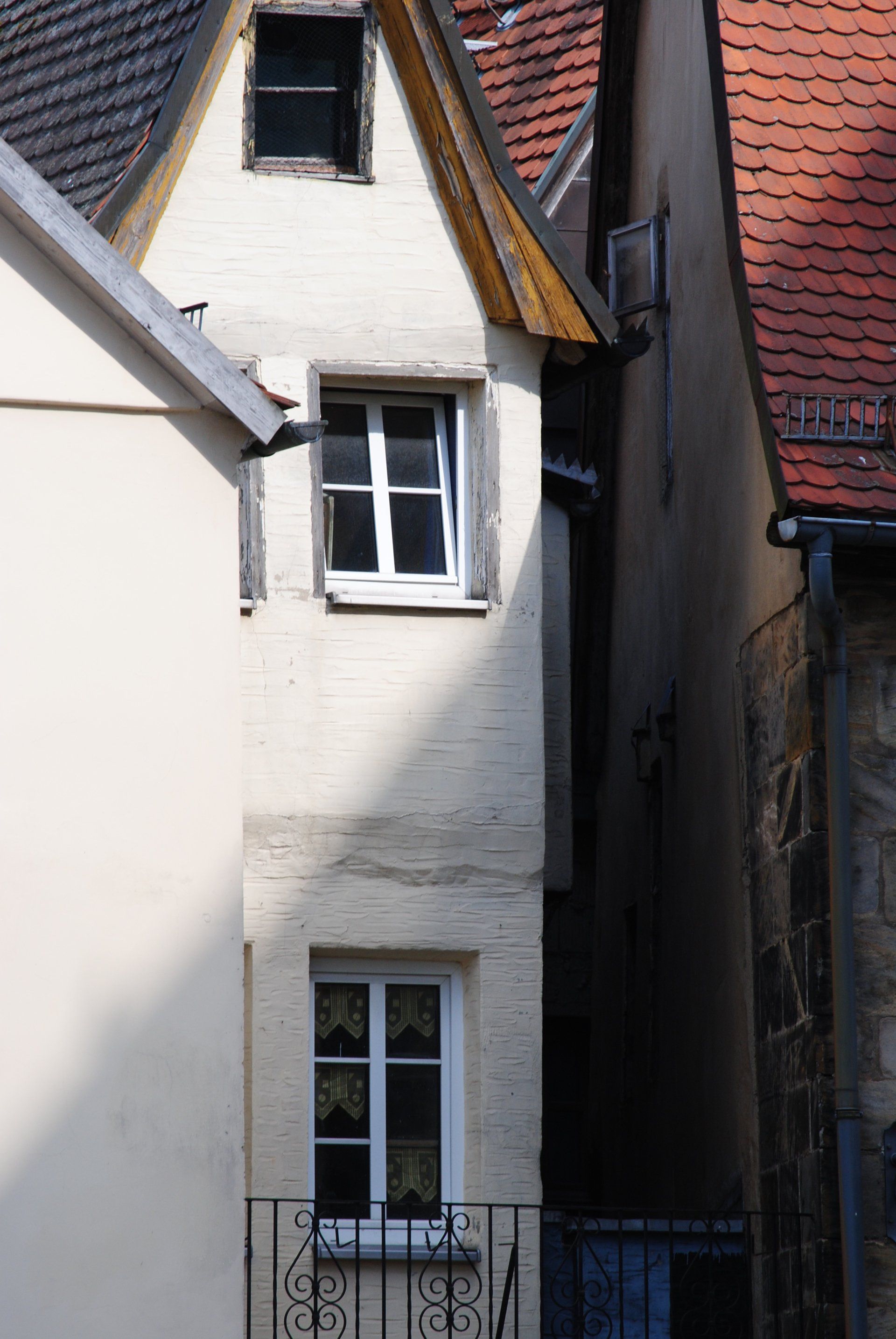A very narrow building with a balcony and a window