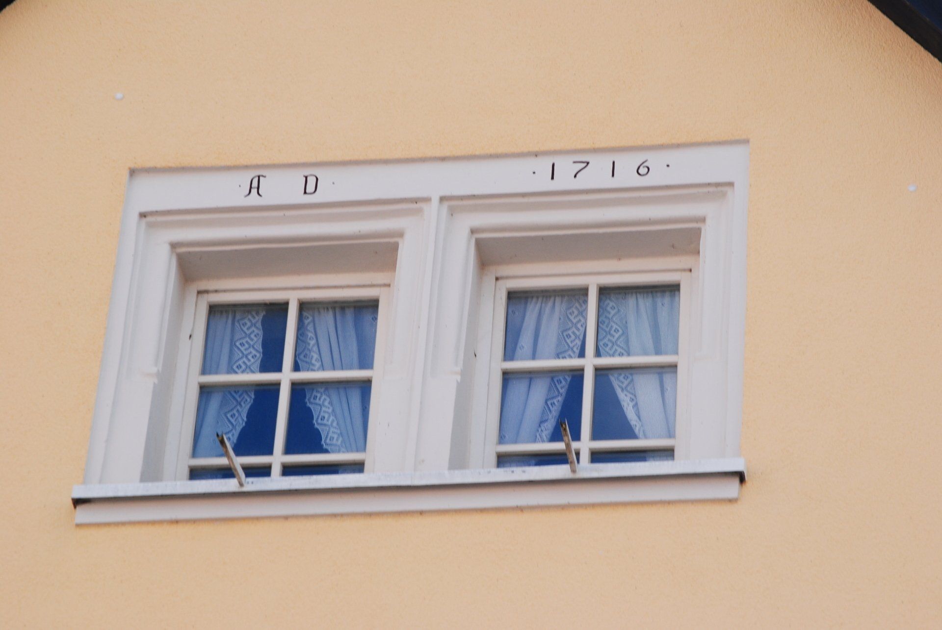 A house with two windows and the date 1716 on it