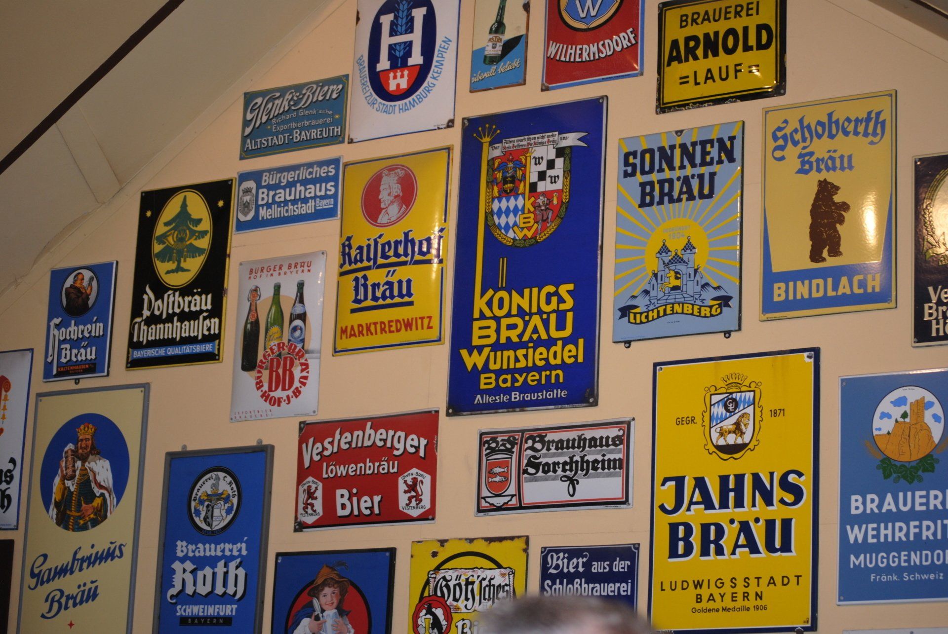 A wall full of signs including jahns brau