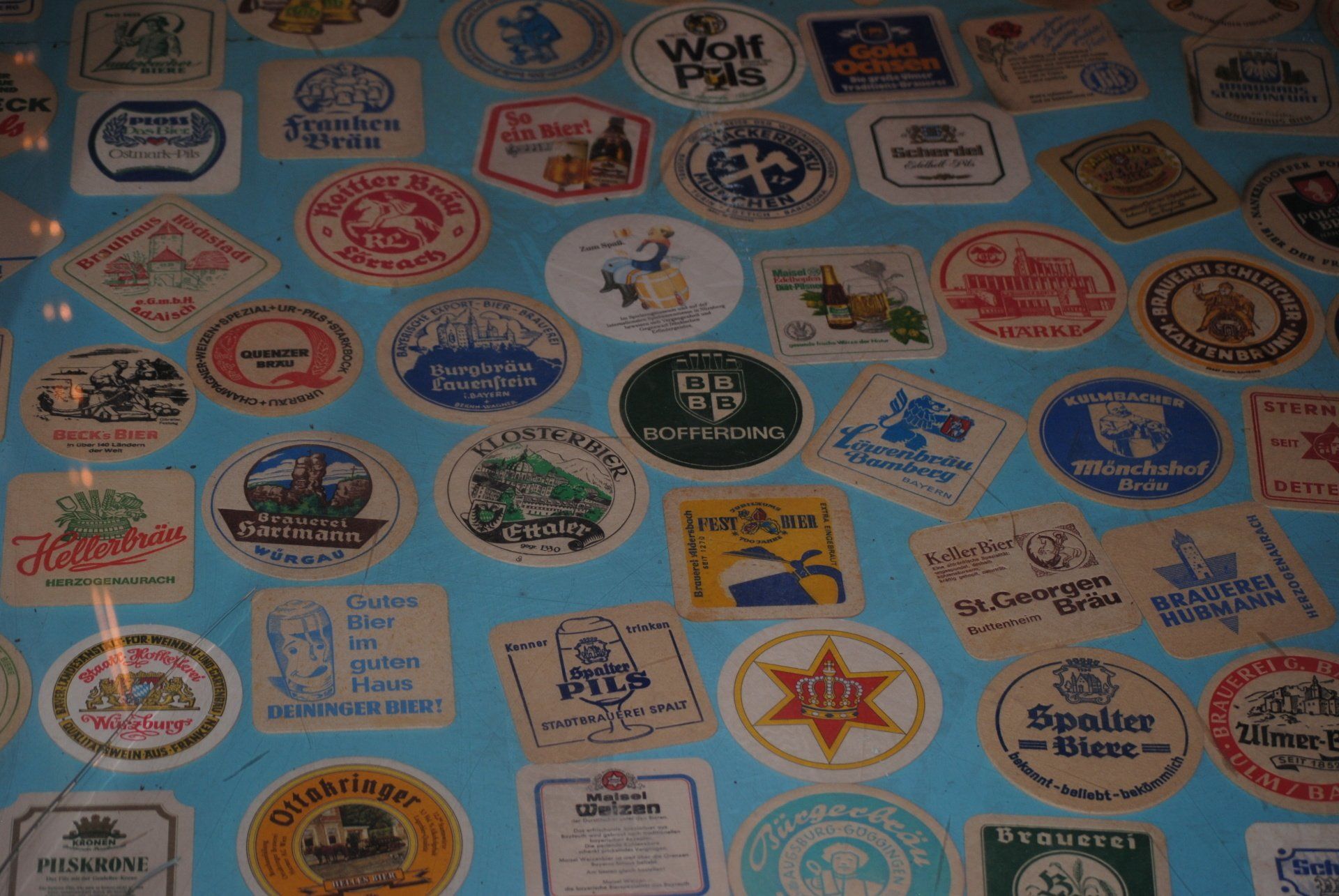 A bunch of beer coasters with one that says wolf point